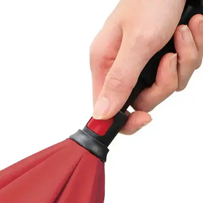 ボタンを押しながら手開き式のさかさま傘。